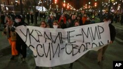 Demonstrators march with a banner that reads: 'Ukraine - Peace, Russia - Freedom' in Moscow, Feb. 24, 2022, after Russia's attack on Ukraine. 