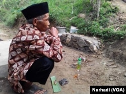 Seorang tetua berdoa dengan membawa sesajen di Kebumen, Jawa Tengah. (Foto: VOA/Nurhadi)