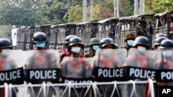 资料照片：在缅甸曼德勒一处路障的缅甸警察和他们身后的军车队。(2022年2月19日)