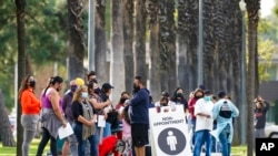 FILE - People wait in line to test for COVID-19 on Jan. 12, 2022, in Long Beach, Calif.