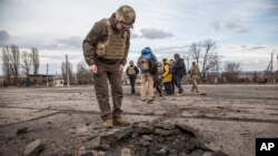 Yon solda Ikrenyen gade yon twou ke yon zam separatis pwo-Risi yo tire nan vilaj Novoluhanske, nan rejyon Luhansk, peyi Ikrèn, Samdi 19 Fevriye 2022. 