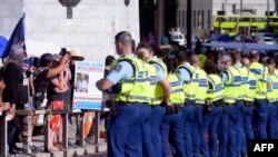 Police conduct an operation to constrain protesters outside the parliament grounds in Wellington on Feb. 22, 2022, as anti-vaccine demonstrators occupy the streets and grounds outside.