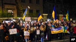 Demonstrators hold placards and flags at a protest outside the Russian Embassy, in London, Feb. 23, 2022. Ukraine urged its citizens to leave Russia as Europe braced for further confrontation Wednesday.