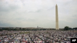 Thousands of people examine the individual panels of the AIDS quilt as it is displayed on the Mall in Washington on Sunday, Oct. 11, 1992. (AP Photo/Stephen R. Brown)