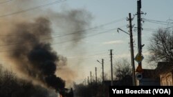 A bus burns as Russia invades Ukraine on Feb. 24, 2022, on a road from Kharkiv to Kyiv. (Yan Boechat/VOA)