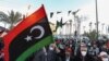 Les gens se rassemblent dans la ville côtière de Tajura, à l'est de la capitale Tripoli, le 16 février 2022, alors qu'ils commémorent la veille du 11e anniversaire du soulèvement qui a renversé l'homme fort de longue date Mouammar Kadhafi en Libye. 