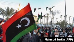 Les gens se rassemblent dans la ville côtière de Tajura, à l'est de la capitale Tripoli, le 16 février 2022, alors qu'ils commémorent la veille du 11e anniversaire du soulèvement qui a renversé l'homme fort de longue date Mouammar Kadhafi en Libye. 