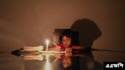 শ্রীলঙ্কার রাজধানী কলোম্বোর অদূরে বিয়াগামা এলাকায় বিদ্যুৎ চলে যাওয়ার পর মোমবাতির আলোয় পড়ছে এক শিক্ষার্থী। (ছবি- এএফপি) 