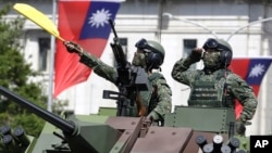 FILE - Taiwanese soldiers salute during National Day celebrations in front of the Presidential Building in Taipei, Taiwan on Oct. 10, 2021.