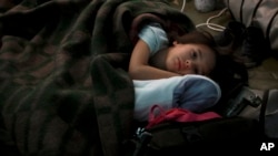 A child from Ukraine sleeps in a tent part of a humanitarian centre for refugees at the Moldovan-Ukrainian border, in Palalanca, Moldova, Feb. 25, 2022. 