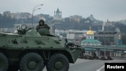 Des militaires de la Garde nationale ukrainienne prennent position dans le centre de Kiev, en Ukraine, le 25 février 2022. (REUTERS/Gleb Garanich)