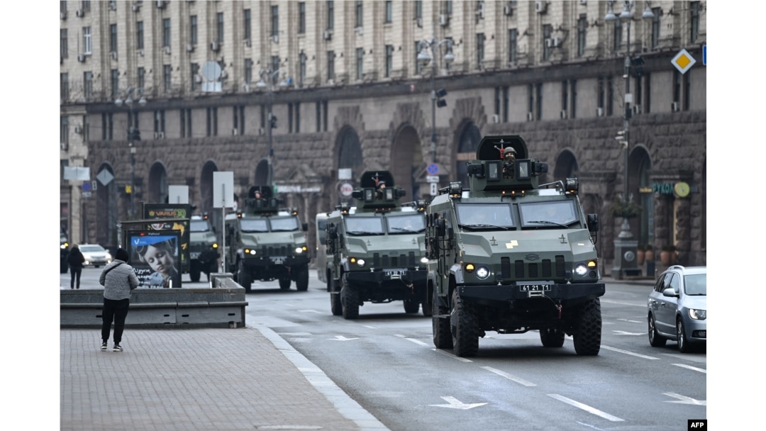 Kendaraan militer Ukraina bergerak melewati alun-alun di Kyiv tengah, 24 Februari 2022, setelah kota-kota dihantam dengan apa yang dikatakan pejabat Ukraina sebagai serangan rudal dan artileri Rusia. (Foto: AFP)