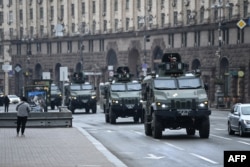 Kendaraan militer Ukraina melewati alun-alun di pusat Kyiv, 24 Februari 2022, setelah kota-kota dihantam oleh apa yang dikatakan pejabat Ukraina sebagai serangan rudal dan artileri Rusia.  (Foto: AFP)
