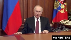 Russian President Vladimir Putin delivers a video address announcing the start of the military operation in eastern Ukraine, in Moscow, in a still image taken from video footage released Feb. 24, 2022.