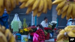 ရန်ကုန်မြို့တွင်း လမ်းဘေးဈေးတခုတွင် ရောင်းချရန်ပြင်ဆင်နေသည့် ပန်းသည်များ။ ၂ ဖေဖော်ဝါရီ ၂၀၂၁။