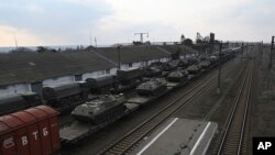 Russian armored vehicles are loaded onto railway platforms at a railway station in region not far from Russia-Ukraine border, in the Rostov-on-Don region, Russia, Feb. 23, 2022. 