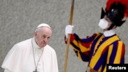 FILE - Pope Francis walks past a Pontifical Swiss Guard as he arrives for the weekly general audience at the Paul VI Hall at the Vatican, Feb. 23, 2022.