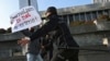 FILE - Police restrain a protester in front of the Parliament building in Baku, Azerbaijan, Dec. 28, 2021. At least eight journalists have been jailed in Azerbaijan since November in a move that press freedom groups characterize as politically motivated and retaliatory.