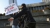 FILE - Police officers restrain a protester during a rally in front of the Parliament building in Baku, Azerbaijan, Dec. 28, 2021.