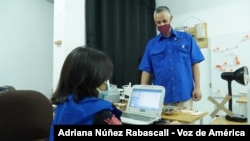 El profesor de electrónica, Francisco Botifoll, enseña robótica a niños en un pequeño salón de Caracas.