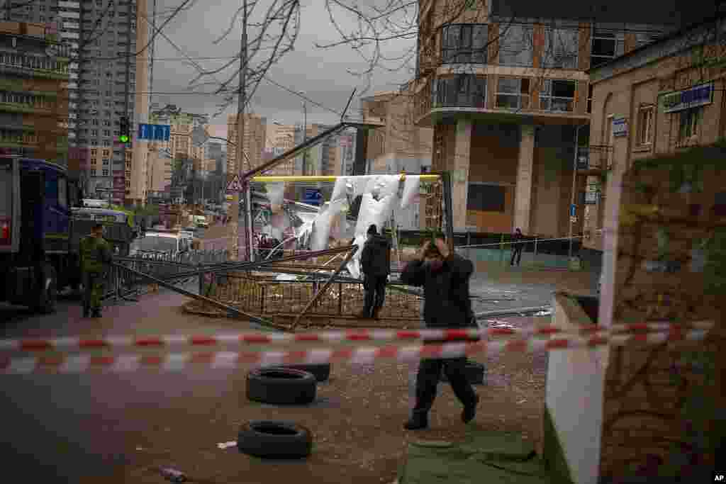 Police officers inspect an area after an apparent Russian strike in Kyiv, Ukraine.