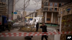 Police officers inspect an area after an apparent Russian strike in Kyiv, Ukraine, Feb. 24, 2022.