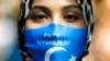资料照片：中国外交部长王毅访问柏林期间，一名参加抗议活动的妇女戴着写有“释放维吾尔人”英文字样的口罩。（2020年9月9日）