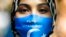 FILE - A woman wears a face mask reading 'Free Uyghurs' as she attends a protest during the visit of Chinese Foreign Minister Wang Yi in Berlin, Sept. 1, 2020. 