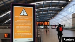 A person walks past a sign at Waterloo station, as a red weather warning was issued due to Storm Eunice, in London on Feb. 18, 2022.