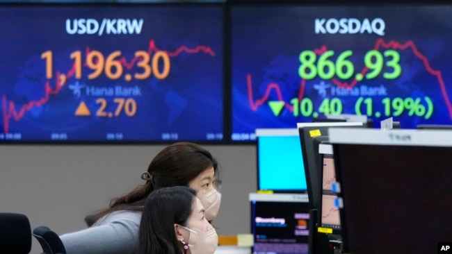 Currency traders watch monitors at the foreign exchange dealing room of the KEB Hana Bank headquarters in Seoul, South Korea, Feb. 24, 2022.