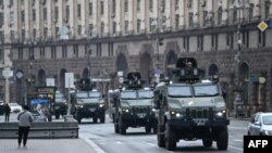 Ukrainian military vehicles move past Independence square in central Kyiv on Feb. 24, 2022.