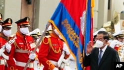 FILE PHOTO- Cambodia's Prime Minister Hun Sen, front right, reviews honorary troops during the country's 68th Independence Day, in Phnom Penh, Cambodia, Tuesday, Nov. 9, 2021. (AP Photo/Heng Sinith)