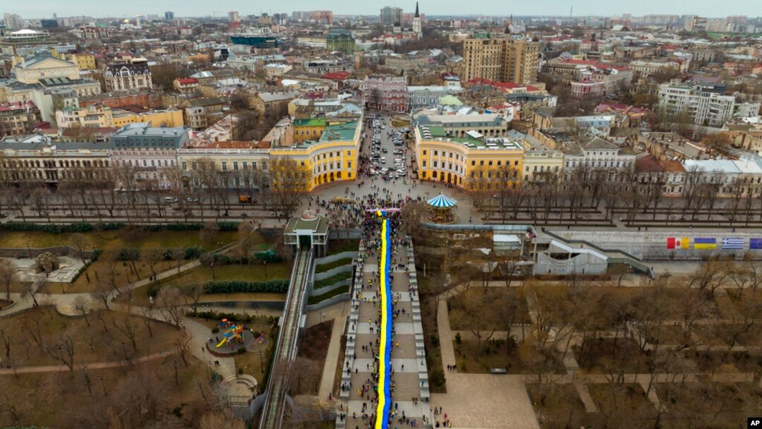 Demonstran menggelar pawai bendera besar Ukraina di sepanjang jalan di Odessa, Ukraina, Minggu, 20 Februari 2022. Indonesia masih terus berkoordinasi dan memantau secara cermat perkembangan di Ukraina. (Foto: AP)