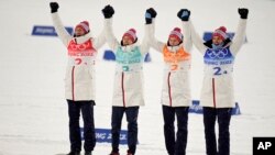 Gold medal finishers from left, Norway's Espen Bjoernstad, Espen Andersen, Jens Luraas Oftebro and silver medalist Germany's Vinzenz Geiger celebrate after the cross-country skiing competition of the team Gundersen large hill/4x5km at the 2022 Winter Olym