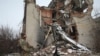 Un militaire ukrainien passe devant un bâtiment détruit sur la ligne de front avec les séparatistes soutenus par la Russie à Mariinka, dans la région de Donetsk, le 7 février 2022.