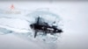 资料照片：俄罗斯一艘核潜艇在北冰洋破冰浮出海面。(2021年3月26日）