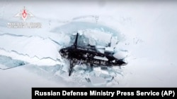 FILE - In this photo released by Russian Defense Ministry on March 26, 2021, a Russian nuclear submarine breaks through the Arctic ice