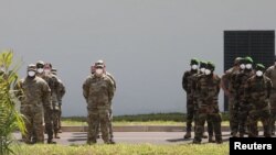 Participants stand at ease during the opening ceremony of the U.S. sponsored Flintlock exercises at the site of the new French-backed international counter-terrorism academy in Jacqueville, Ivory Coast, Feb. 20, 2022.