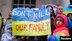 Anti-war demonstrators carry a banner as they protest outside the Museum of Modern Art, near the Russian Embassy, in Ljubljana, Slovenia, Feb. 25. 2022.