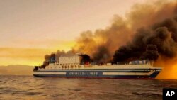 A ferry burns in the Ionian Sea near the island of Corfu, Greece, Feb. 18, 2022. The ferry caught fire overnight, while heading to southern Italy, authorities said.