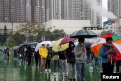 홍콩 주민들이 22일 비 내리는 가운데 코로나 검사 차례를 기다리고 있다.