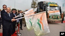 India’s foreign secretary Harsh Vardhan Shringla, 2nd left, and Afghanistan’s ambassador to India Farid Mamundzay, left, flag off the trucks carrying wheat from India at the Attari-Wagah border between India and Pakistan, near Amritsar, India, Feb. 22, 2022.