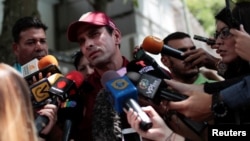 El líder opositor venezolanno, Henrique Capriles, (centro) habla con los periodistas después de emitir su voto durante las elecciones primarias de la oposición en Venezuela, el domingo, 10 de septiembre, de 2017.