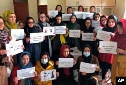FILE - Afghan women hold signs of protest demanding broader rights, in Kabul, Afghanistan, Dec. 27, 2021.