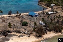 ARCHIVO - En esta foto proporcionada por las Fuerzas de Defensa de Australia, los escombros de edificios y árboles dañados se encuentran esparcidos por la isla Atata en Tonga, el 28 de enero de 2022, luego de la erupción de un volcán submarino y el posterior tsunami.