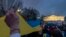 Sejumlah orang memegang bendera Ukraina dalam ukuran besar dalam aksi protes Invasi Rusia terhadap Ukraina yang berlangsung di depan Gedung Putih, Washington, pada 24 Februari 2022. (Foto: AP/Andrew Harnik)