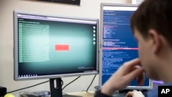FILE - A cybersecurity worker develops computer code in an office in Moscow, Oct. 25, 2017. 