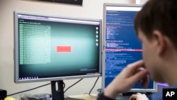 FILE - A cybersecurity worker develops computer code in an office in Moscow, Russia, Oct. 25, 2017. The U.S. and allies are bracing for the possibility that a Russian invasion of Ukraine would have a ripple effect in cyberspace.