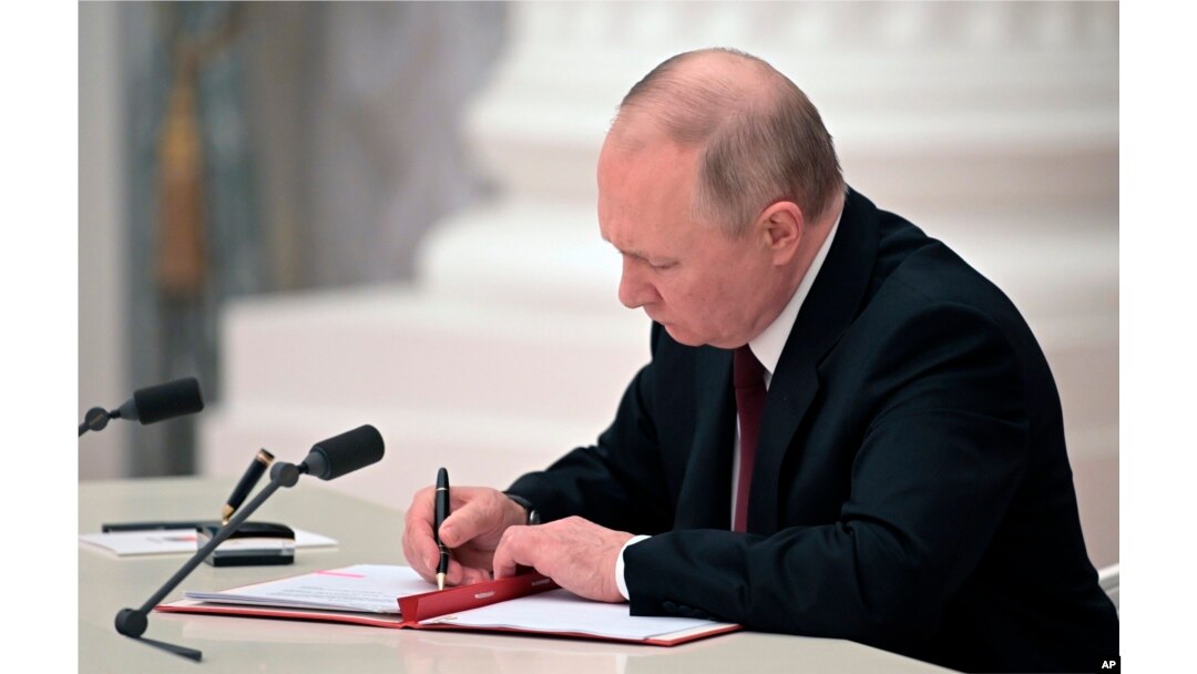 El presidente ruso, Vladimir Putin, firma un documento que reconoce la independencia de las regiones separatistas en el este de Ucrania en el Kremlin en Moscú, el 21 de febrero de 2022.