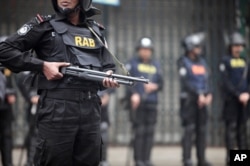 Anggota Batalyon Aksi Cepat Bangladesh (RAB) berjaga di depan kantor oposisi Partai Nasionalis Bangladesh (BNP) selama pemogokan nasional di Dhaka, Bangladesh, Selasa, 11 Desember 2012. (Foto: AP)